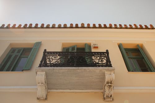 Free Close-up of a neoclassical balcony with ornate wrought iron railing in Athens, Greece. Stock Photo