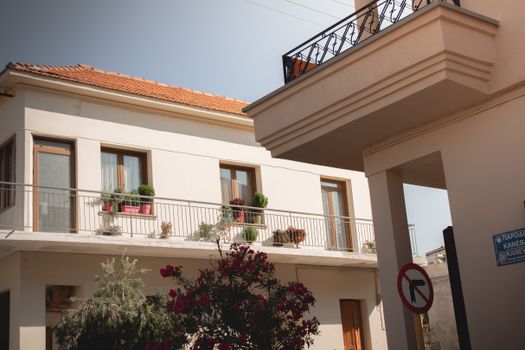Traditional Greek house facade with potted plants and balcony details.