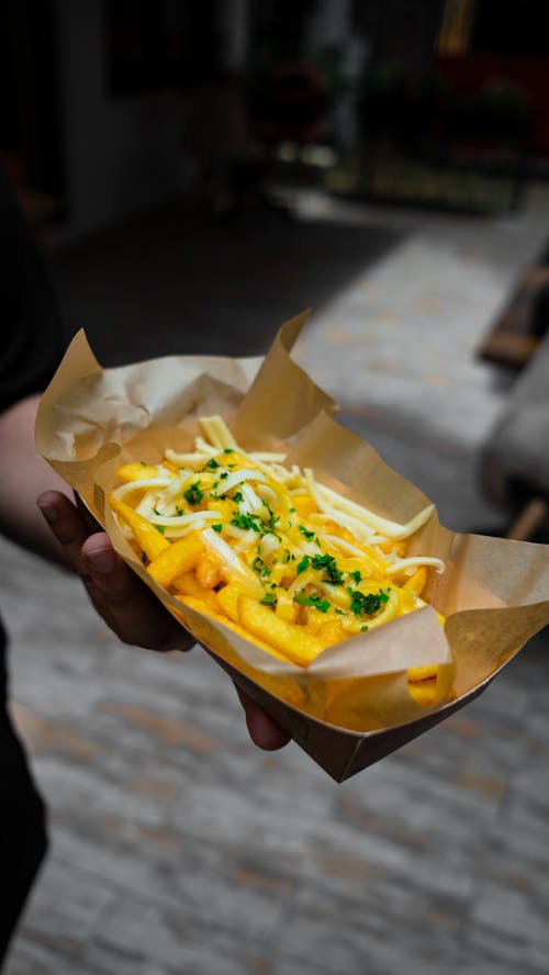 A Person Holding Fried French Fries