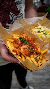 Close-up of shrimp and cheese fries with herbs for a tasty meal.