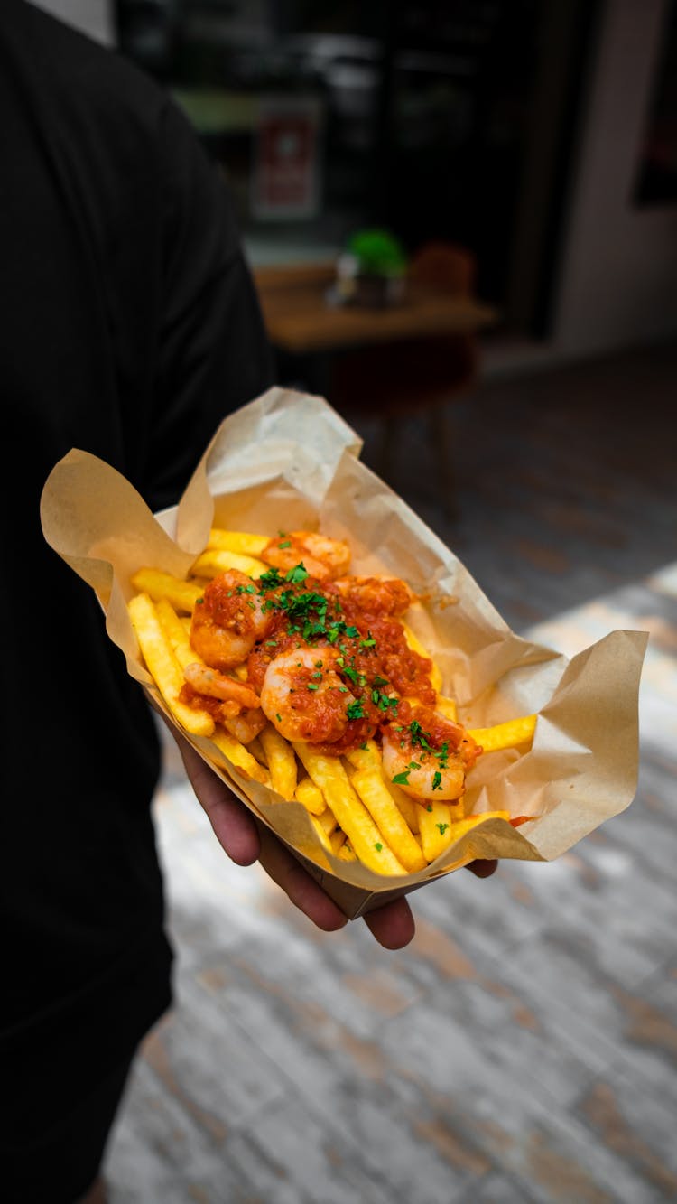 Person Holing Fish And Chips Wrapped In Paper