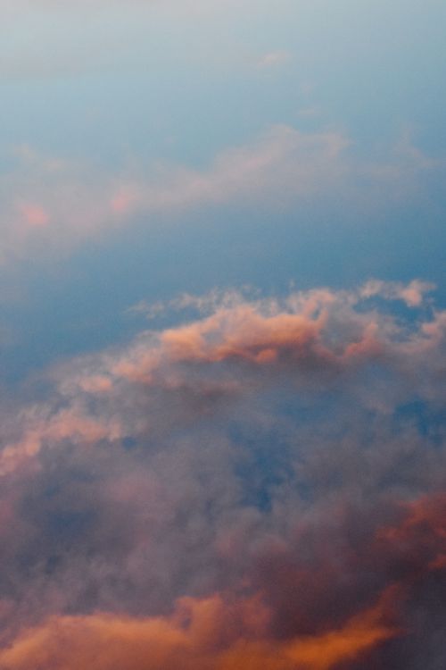 Free A serene view of colorful clouds at sunset with soft pastel hues creating a calming atmosphere. Stock Photo
