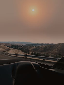 Breathtaking road trip through desert mountains under the setting sun, capturing an adventurous journey.