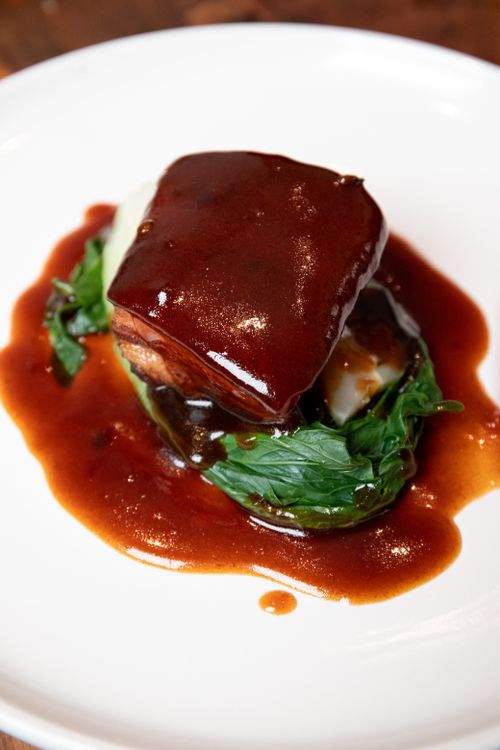 Free A savory dish featuring braised pork with vegetables and sauce on a white plate. Stock Photo