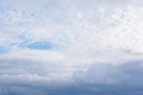 Free A tranquil view of a blue sky with soft white clouds, perfect for nature backgrounds. Stock Photo