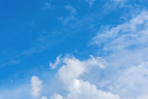Free Vivid blue sky with scattered white clouds on a clear day. Ideal for backgrounds. Stock Photo
