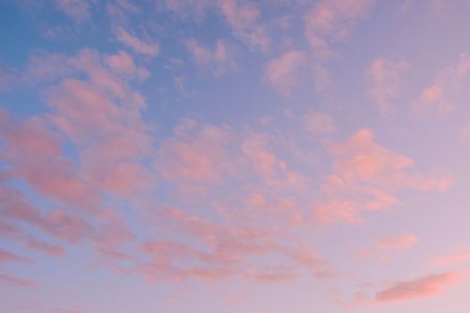 A tranquil sky filled with soft pink clouds during sunset, offering a peaceful view.