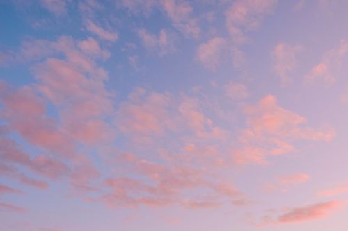 Free A tranquil sky filled with soft pink clouds during sunset, offering a peaceful view. Stock Photo