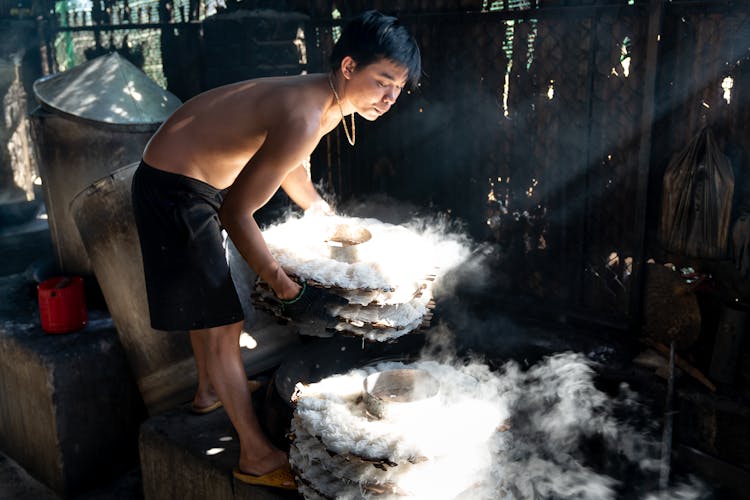 Man Cooking Rice Noodles And Putting Them On Bamboo Trays 