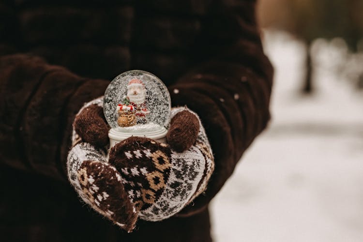 Hands In Wool Gloves Holding Christmas Snowball