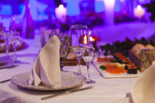 Sophisticated table setting with sushi platter, candlelights, and elegant glassware, perfect for fine dining ambiance.