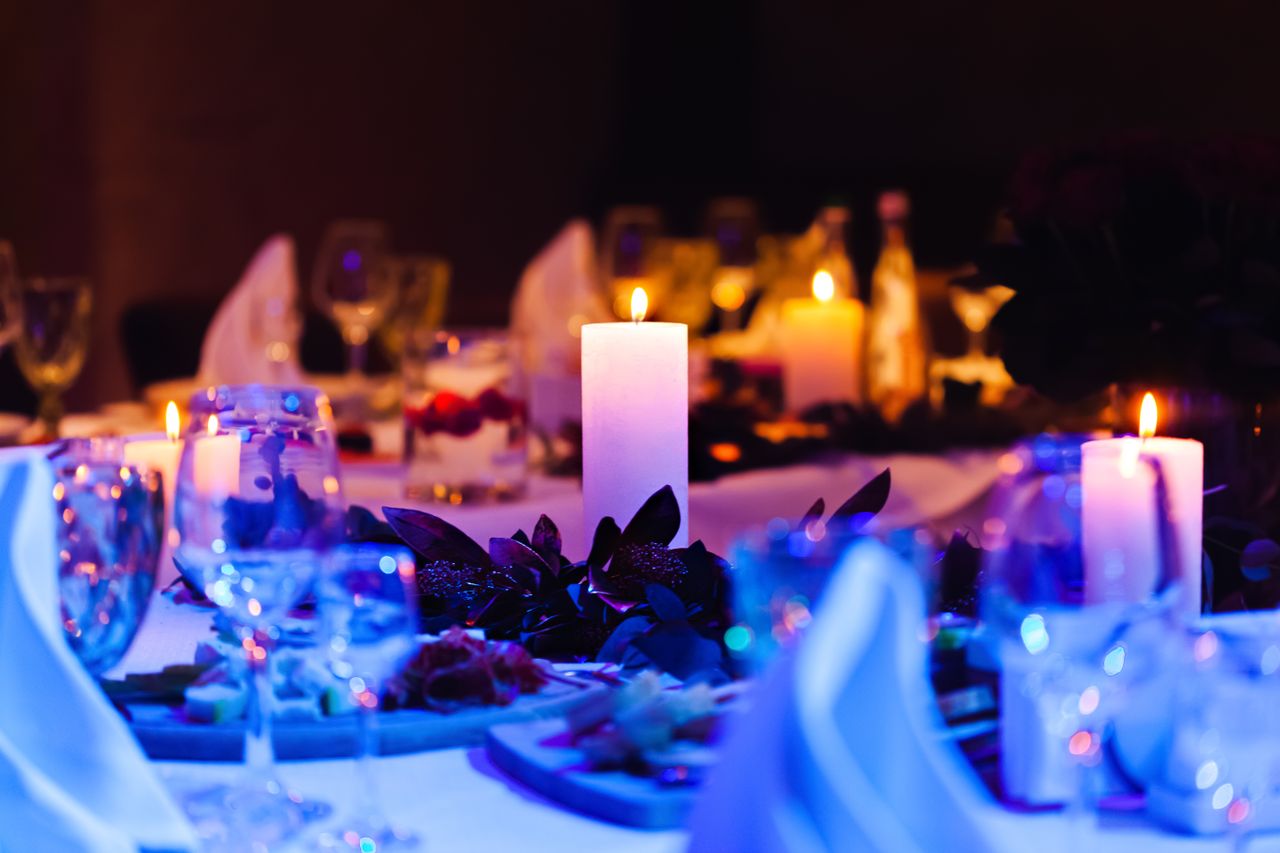 Romantic candlelit dinner setup with wine glasses and floral decor