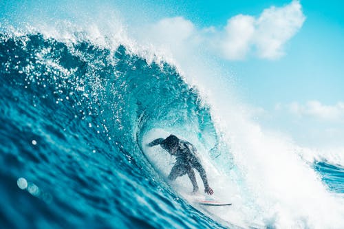Free Unrecognizable energetic surfer riding azure sea wave Stock Photo