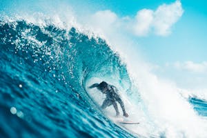 Unrecognizable energetic surfer riding azure sea wave