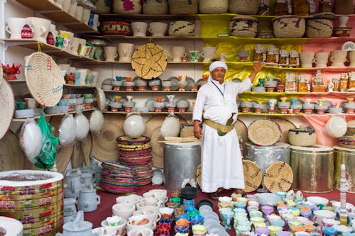 Free Man Showing Products in His Store Wearing Traditional Clothing  Stock Photo