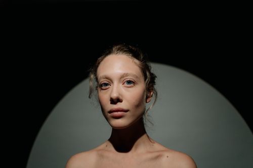 Free Close-up portrait of a woman in studio lighting highlighting facial features. Stock Photo