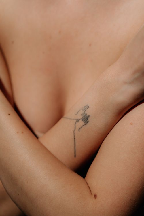 Free An artistic close-up of arms with a delicate line tattoo, symbolizing intimacy and self-care. Stock Photo