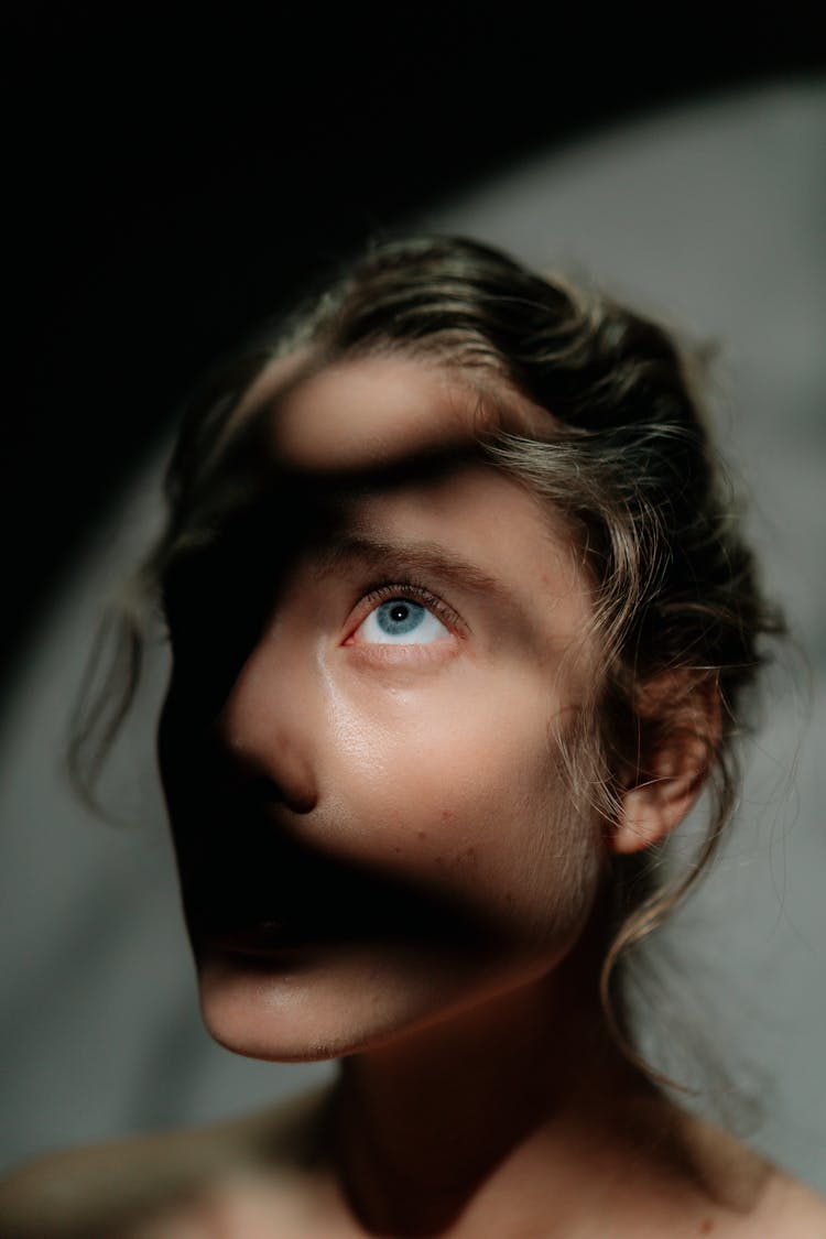 A Woman Looking Up With Shadows On Her Face