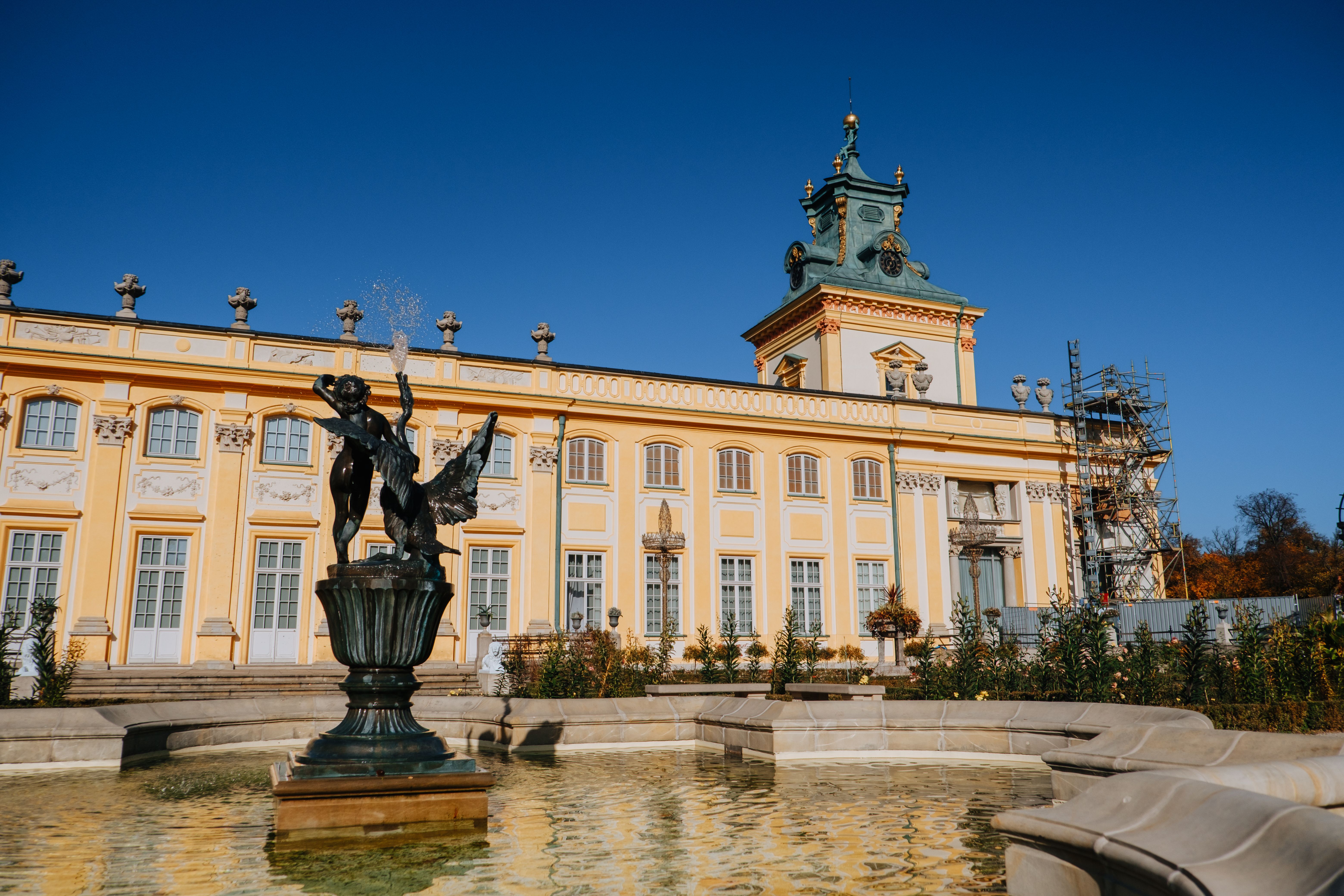Palace facade and formal gardens with fountain sculpture