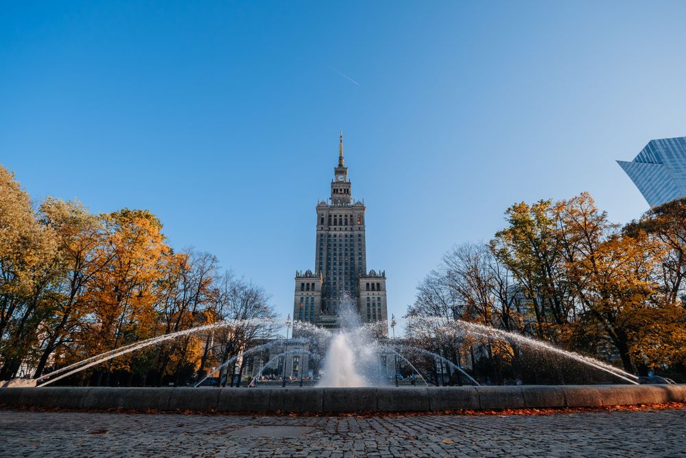 Palatul Culturii și Științei din Varșovia, cu fântâna din față și copaci de toamnă