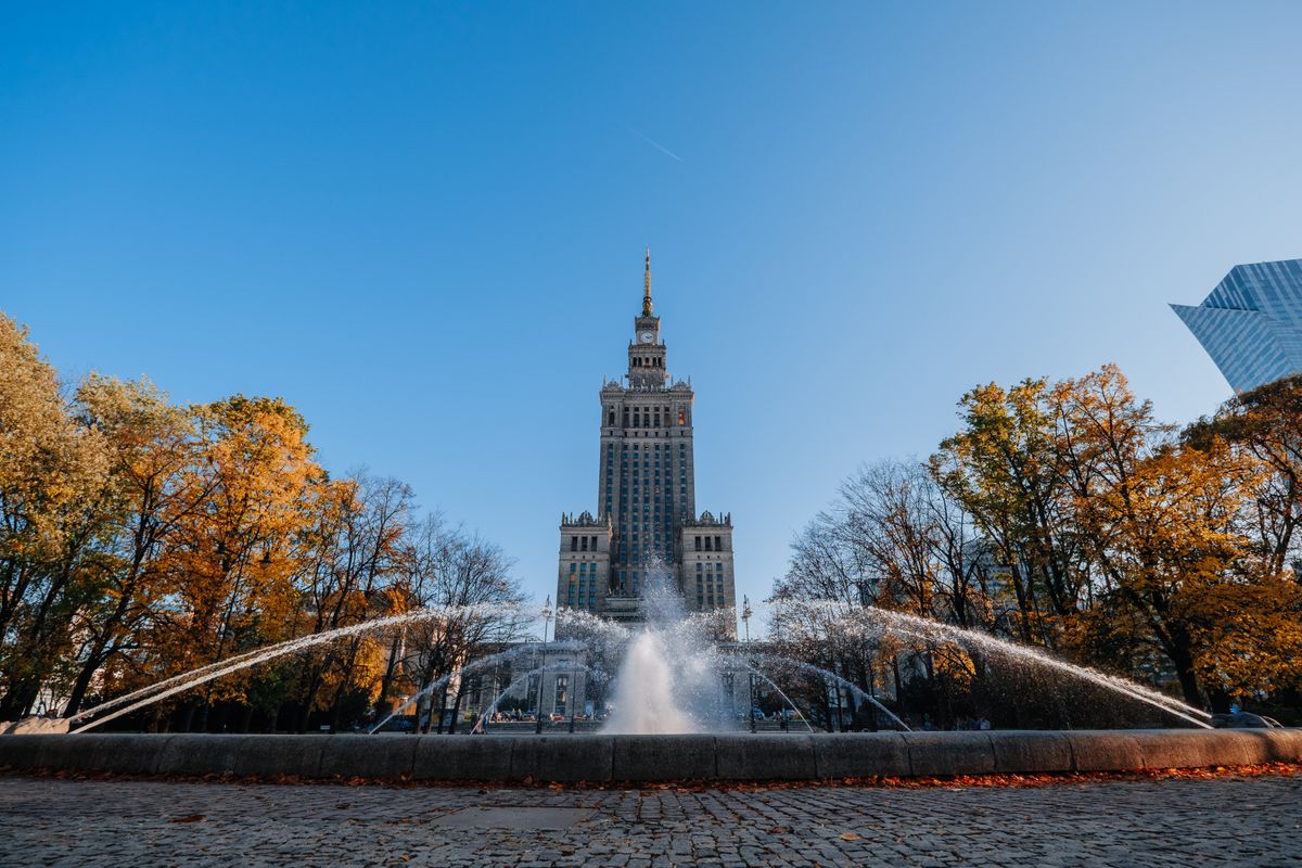 The Palace of Culture and Science in Warsaw with the fountain and trees in front