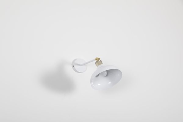A white wall lamp photographed against a plain backdrop, photo by Prem Singh Tanwar on Pexels