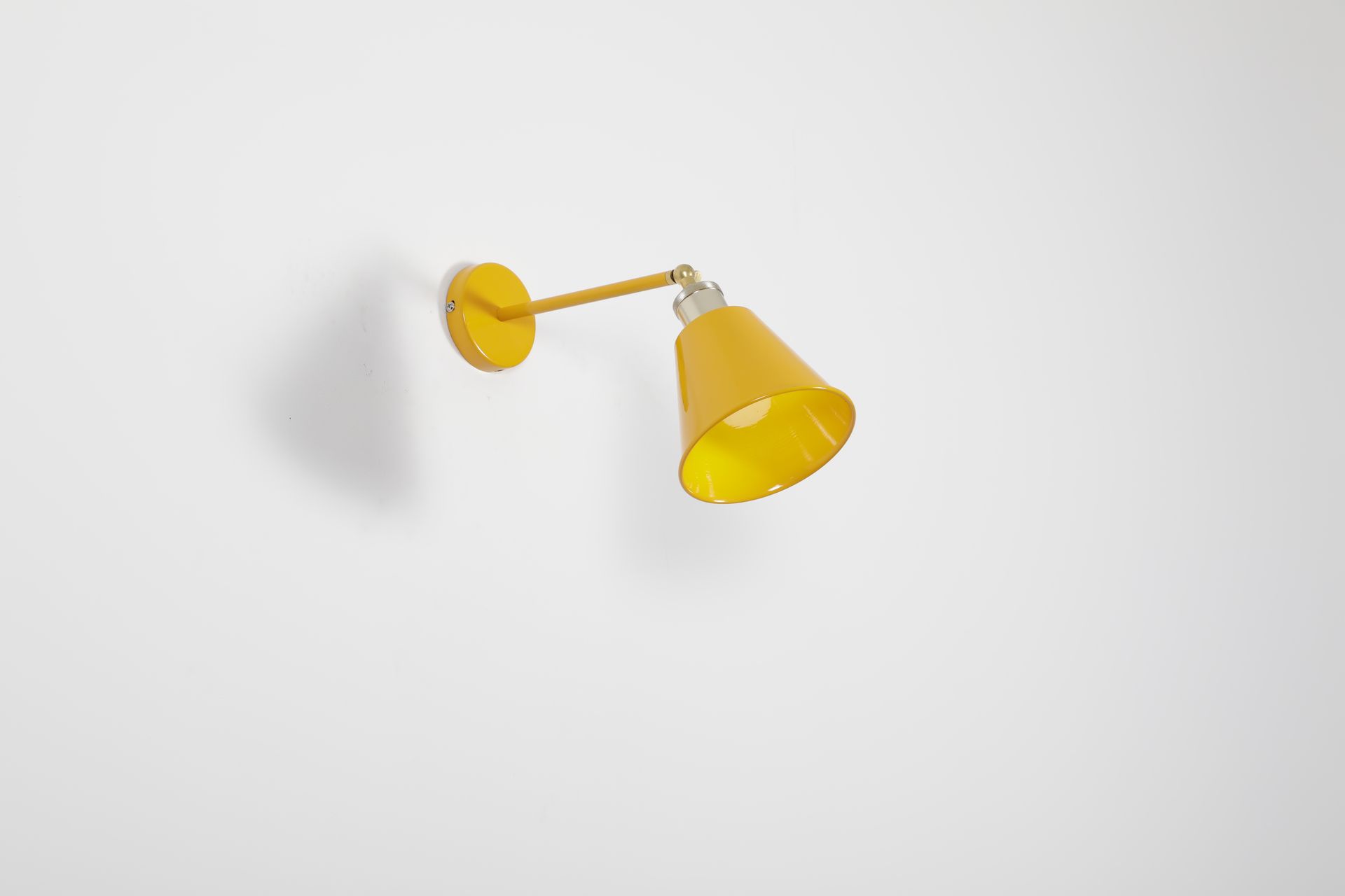 A sleek yellow wall lamp mounted on a plain white wall, perfect for modern decor.