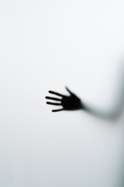 Silhouette of Hand on Glass