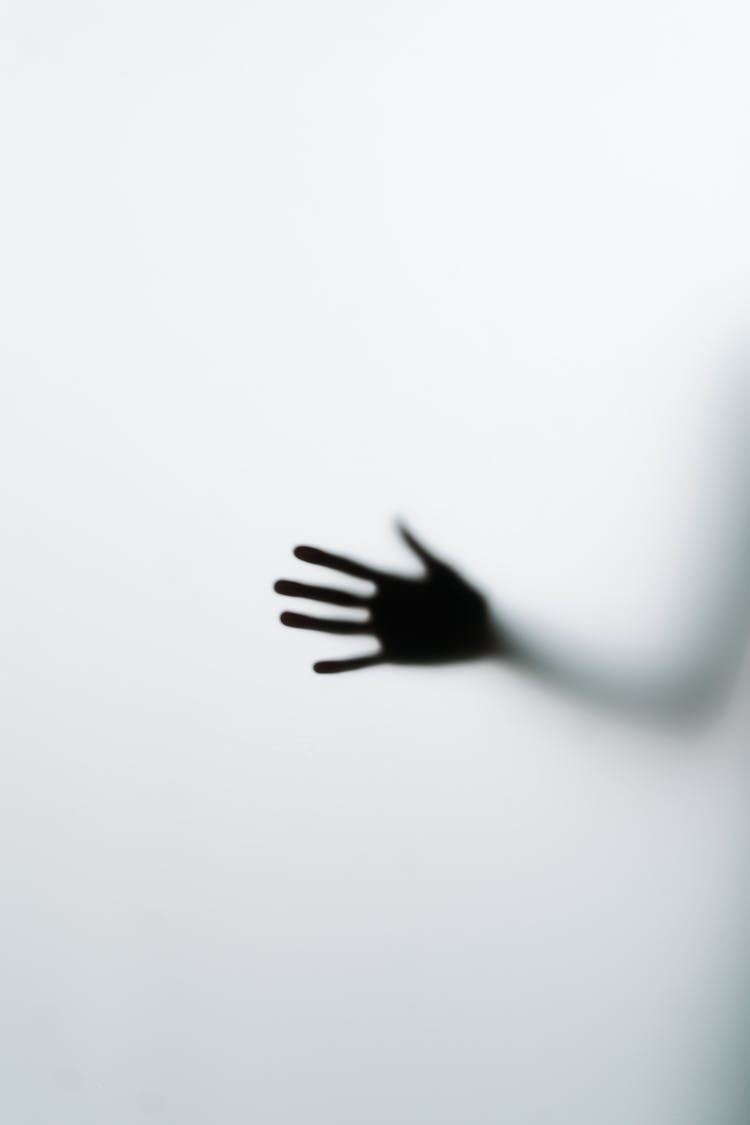 Silhouette Of Hand On Glass