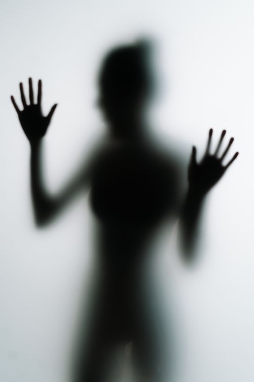 Free Conceptual image of a silhouette behind frosted glass, playing with light and shadow. Stock Photo