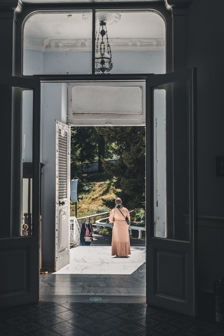 Women Walking In And Out Of A Building 