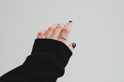 A Person in Black Long Sleeve Shirt With Black Nail Polish