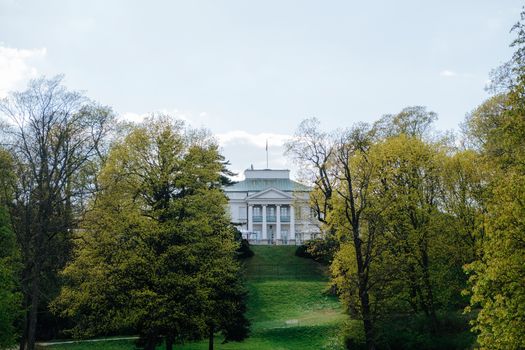 White Concrete Building Near Green Trees Under White Sky