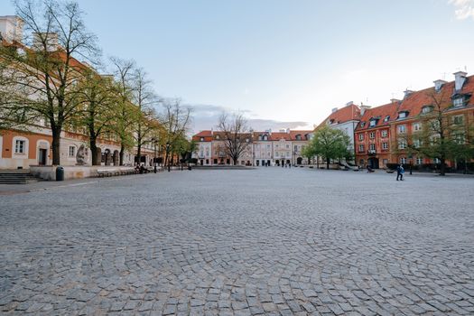A picturesque empty European square with cobblestone pavement and colorful buildings at daytime.
