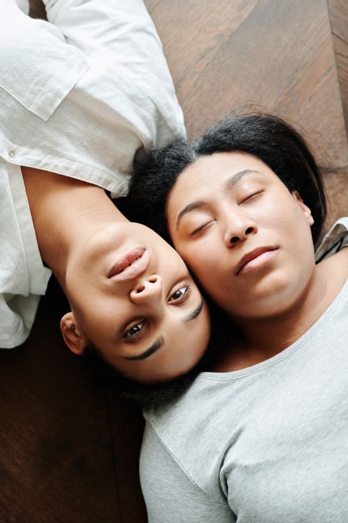 Free Tender embrace of a couple lying with eyes closed, representing love and serenity. Stock Photo