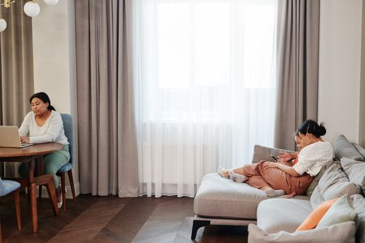 A family sharing quality time at home, engaged with modern technology, showcasing love and togetherness.
