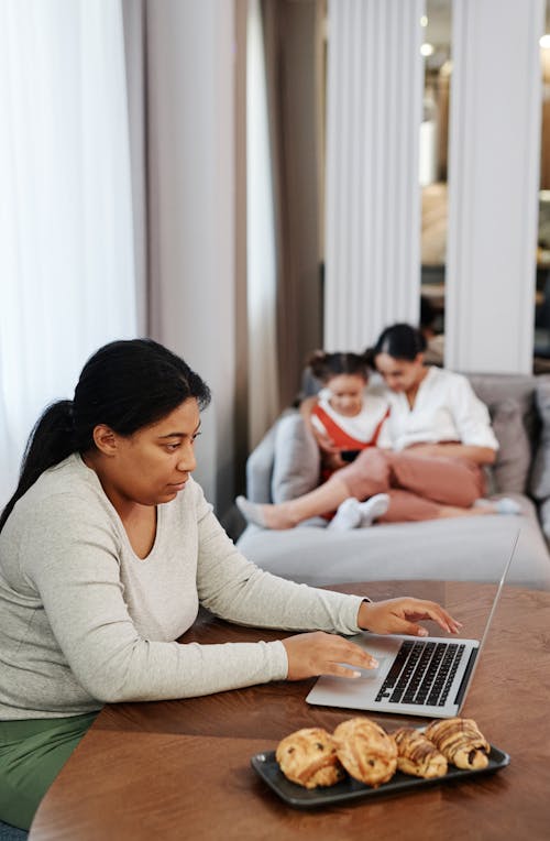 Free Woman in Long Sleeve Shirt Using a Laptop Computer Stock Photo
