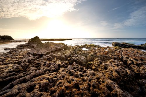 Free Dramatic sunrise over coastal rocks with powerful seascape view. Stock Photo