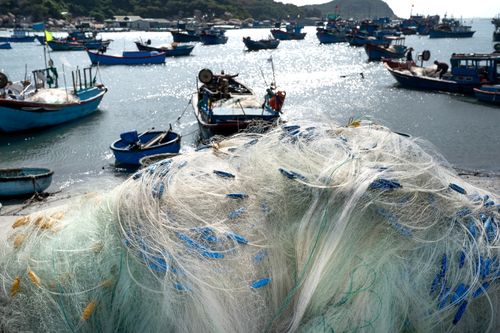 Free Bright fishing nets overlooking a vibrant harbor filled with traditional fishing boats. Stock Photo