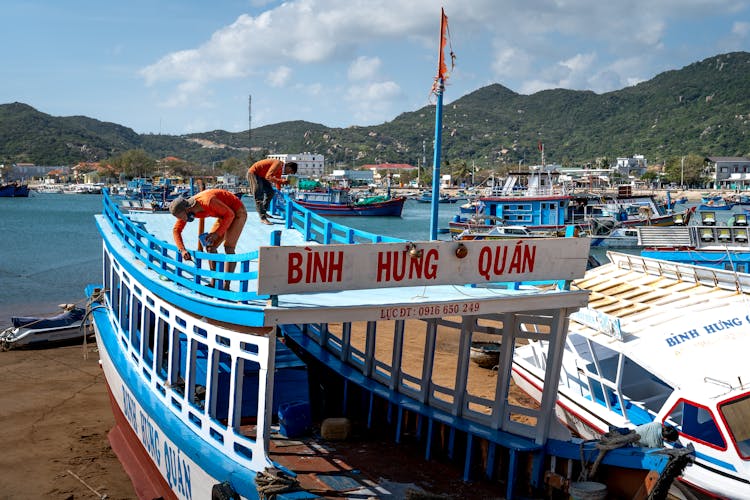 Photo Of Men Painting A Boat