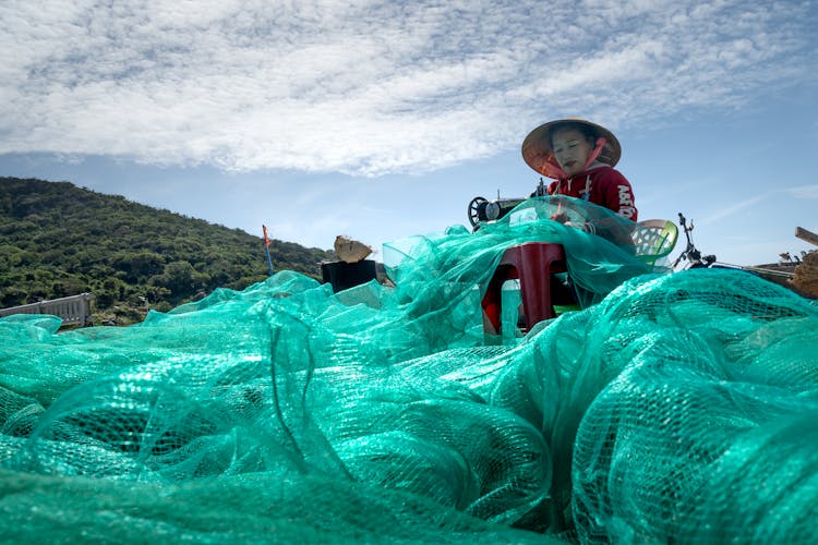 Vietnamese Woman Sewing A Fishing Net 