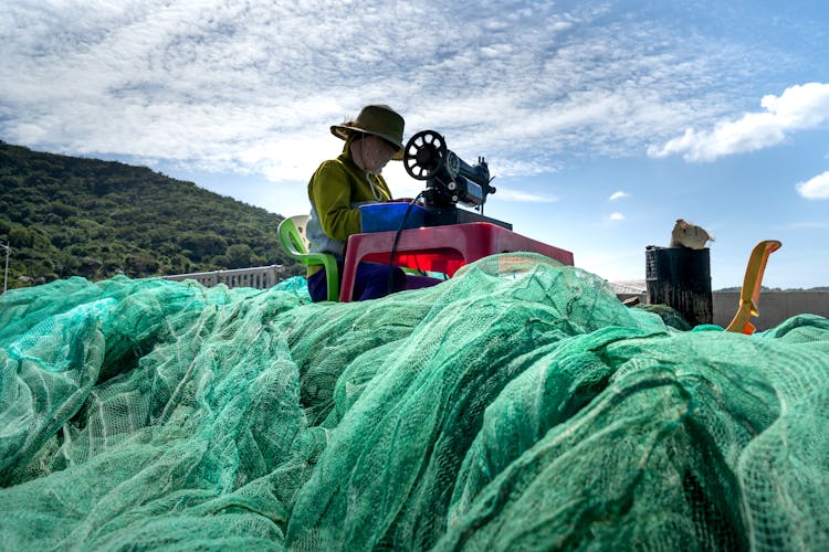 Woman Sewing A Fishing Net In Vietnam