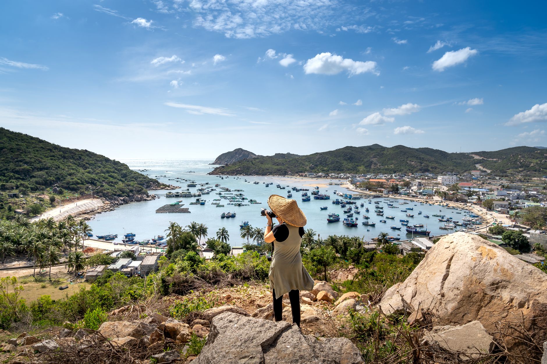 A picturesque view of Vinh Hy Bay in Vietnam with boats and lush hills, captured by a traveler.
