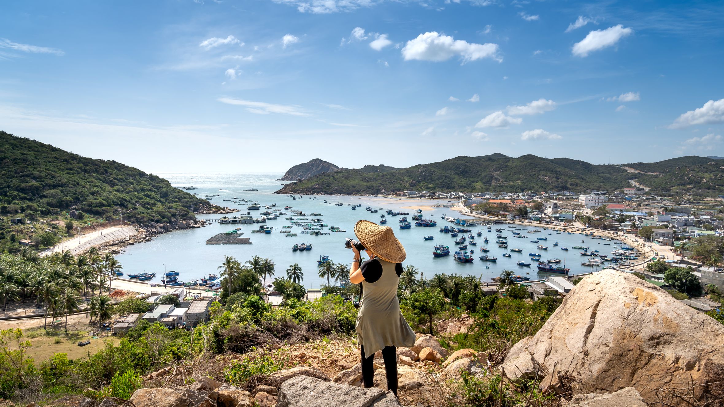 A picturesque view of Vinh Hy Bay in Vietnam with boats and lush hills, captured by a traveler.