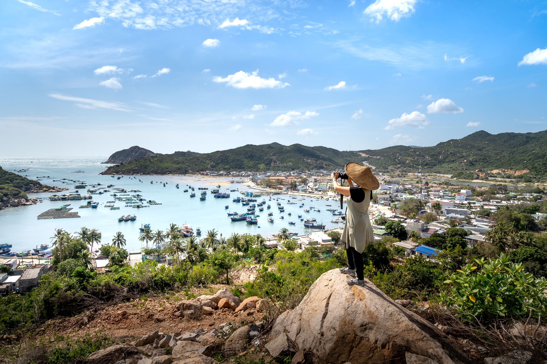 Capture the essence of Vinh Hy Bay with a photographer overlooking the serene seascape and hills.