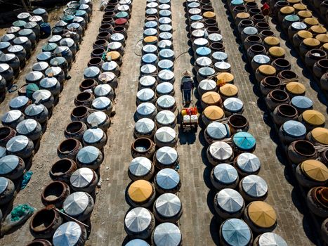 Worker in Hat among Barrels
