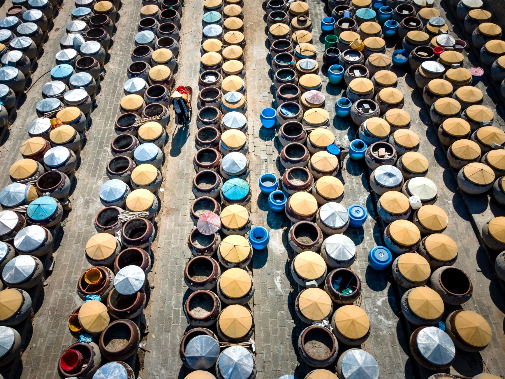 Aerial shot showcasing rows of traditional fermentation jars in a Chinese setting.