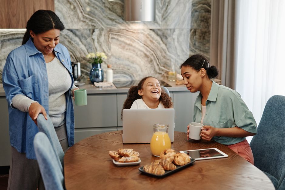 A joyful family shares a morning meal in a modern kitchen setting.