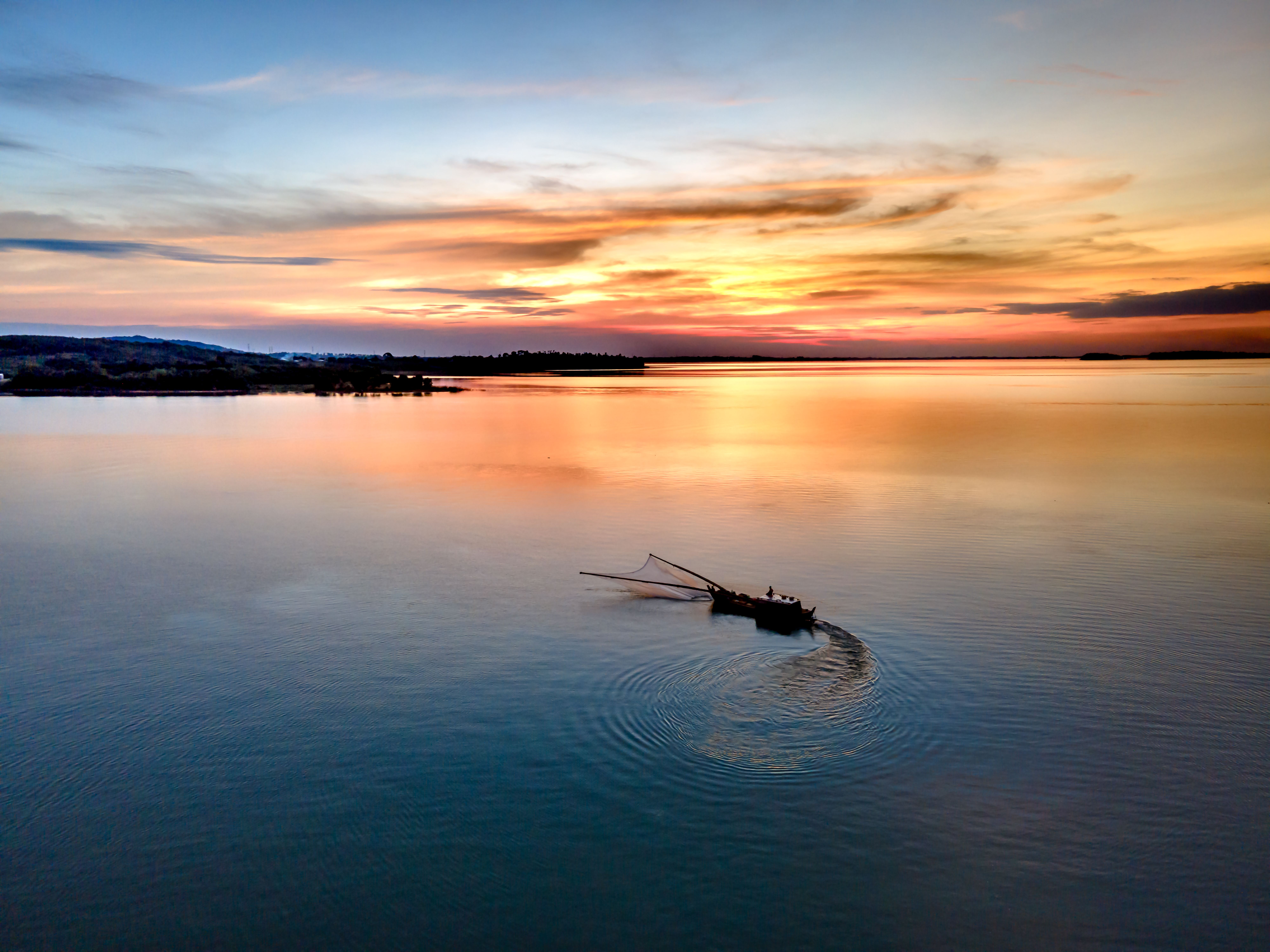 Silhouette of a Boat on a Sea During Sunset · Free Stock Photo