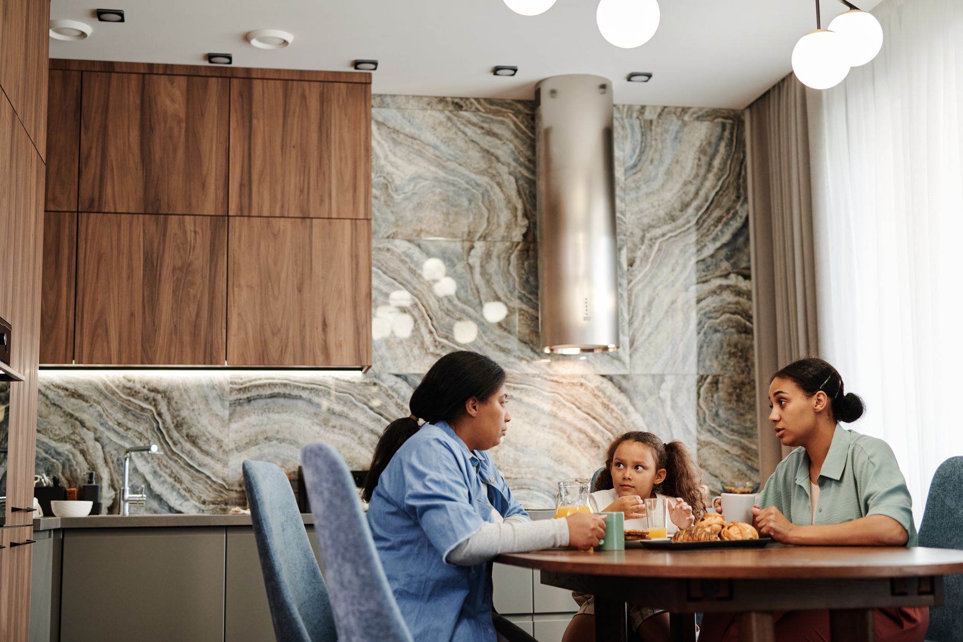 A mother and daughter sharing a quiet conversation at the kitchen table
